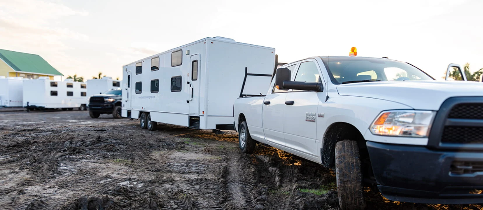 A DRG service truck tows a mobile equipment trailer into a base camp.