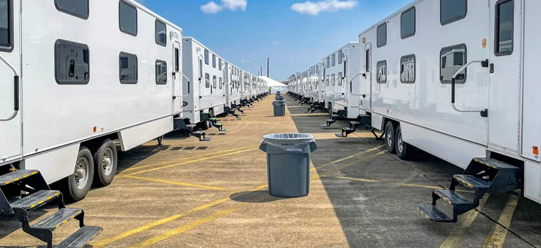 Two rows of white mobile equipment trailers.