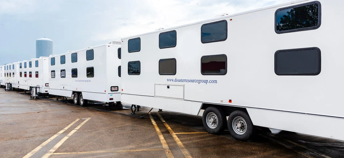 A row of white mobile housing trailers.