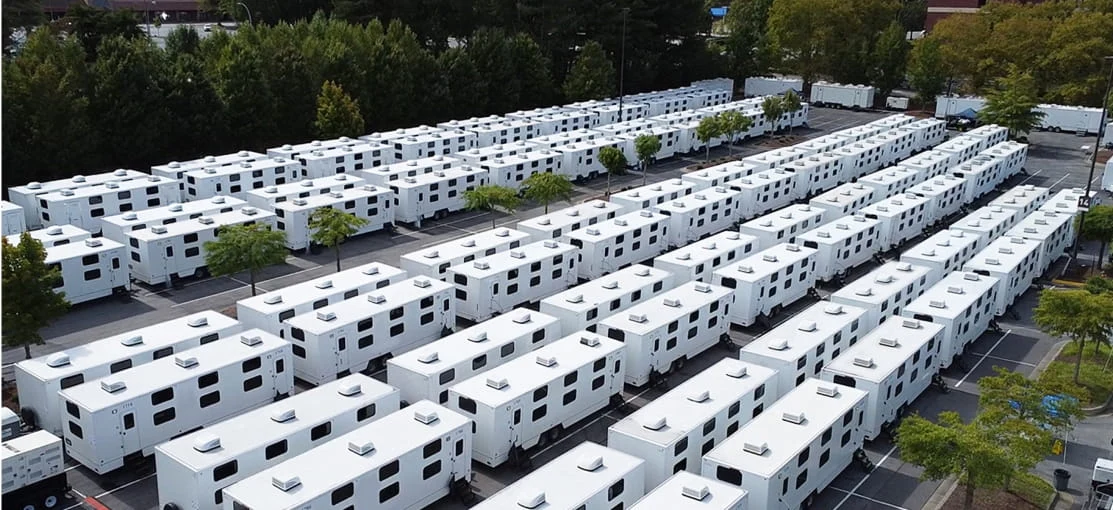 Rows of white DRG mobile equipment trailers ready to deploy.