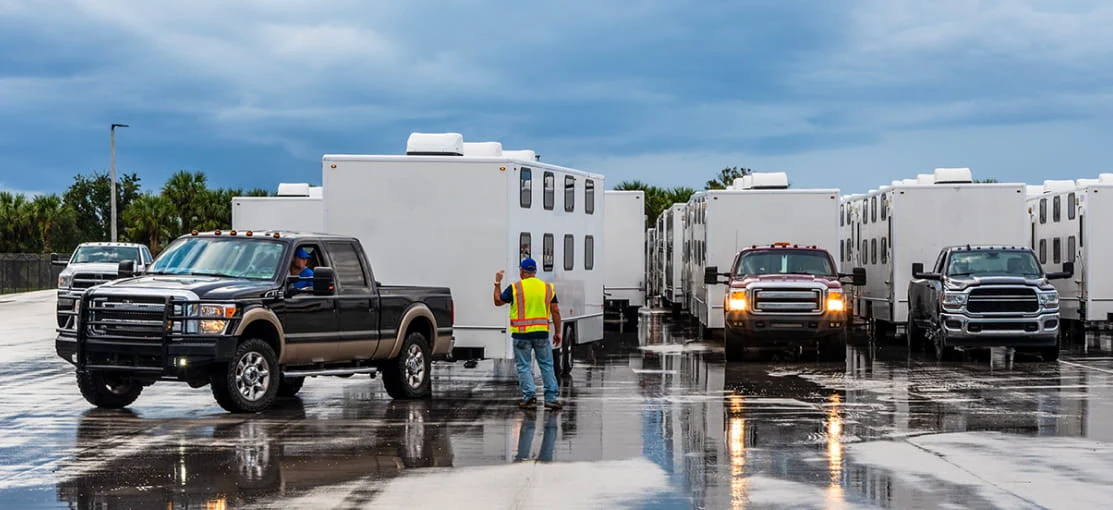 DRG trucks arrive at a disaster site with mobile equipment trailers in tow.