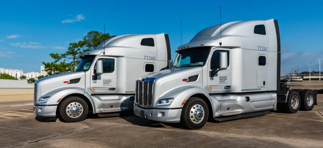 Two DRG semi-trucks parked without trailers.