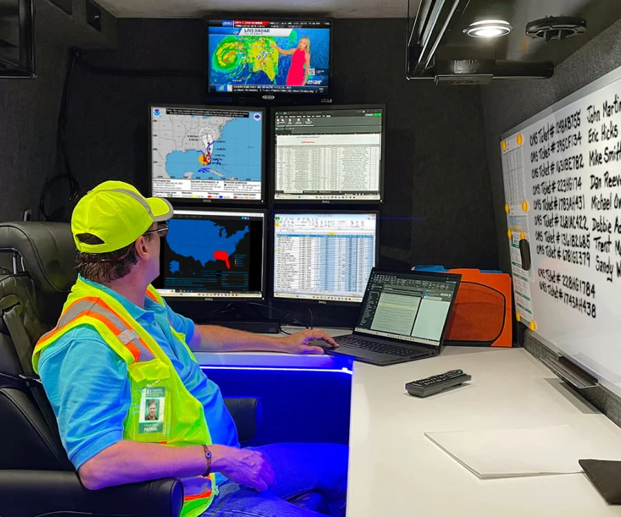 A DRG employee sits at displays inside a mobile command center.