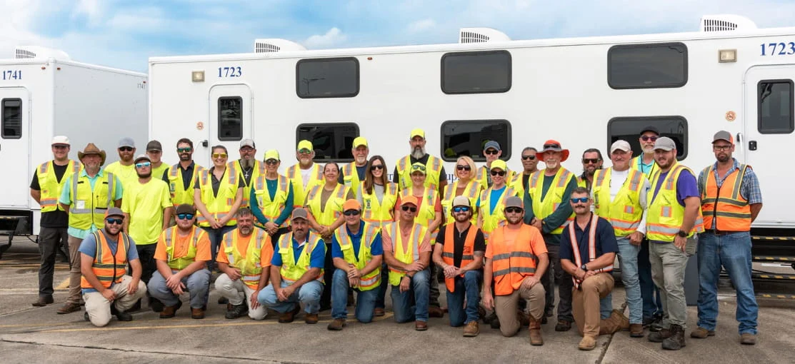 DRG employees pose for a photo on a disaster site.