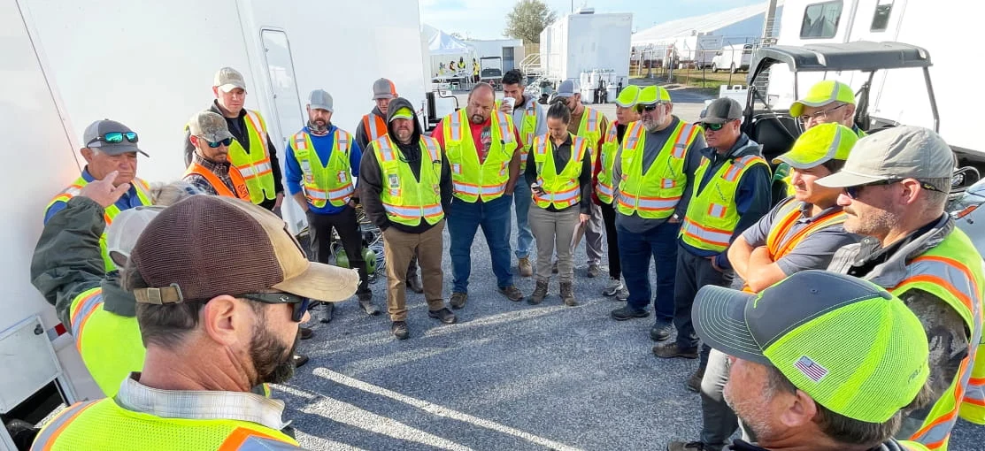 DRG team members gather for a meeting at a base camp.