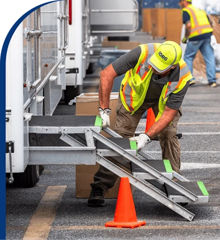 A DRG employee adjusts the steps to a mobile equipment trailer.