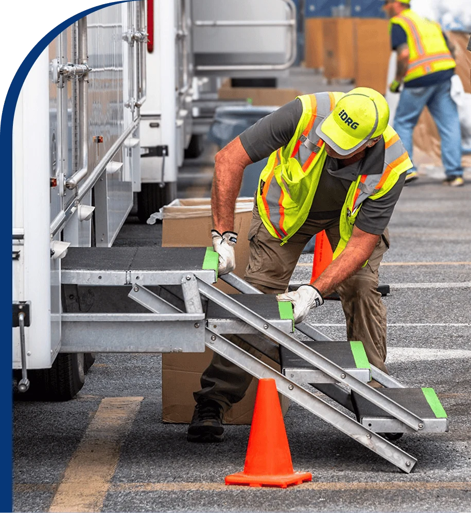 A DRG employee adjusts the steps to a mobile equipment trailer.