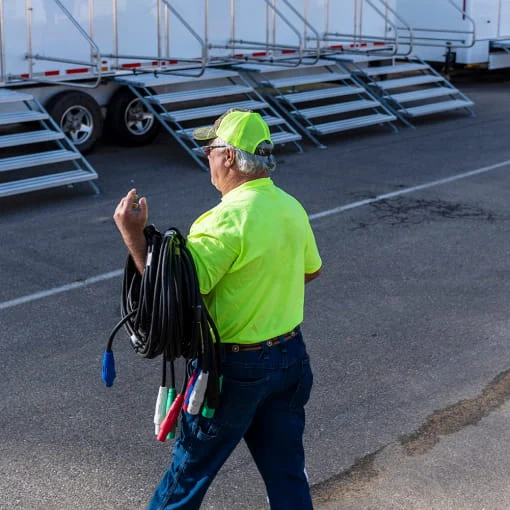 A DRG employee with power cables at a disaster base camp.