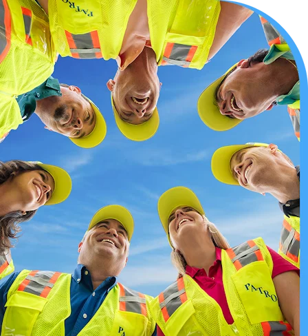 A DRG disaster response team dressed in yellow vests huddled in a circle.
